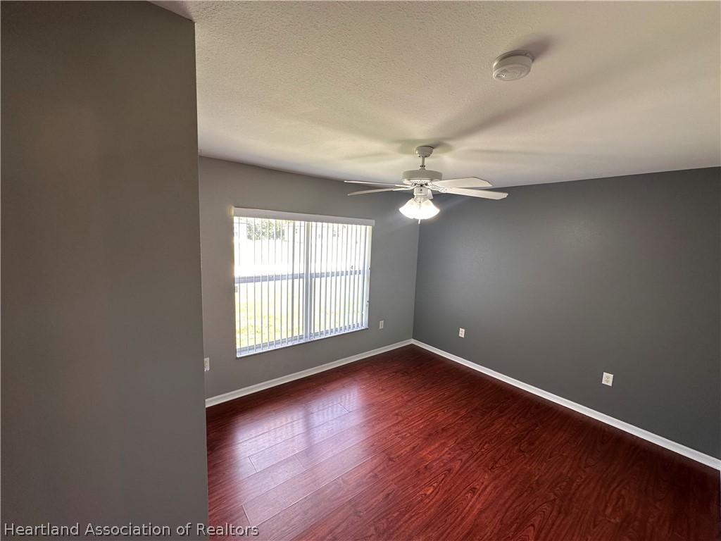 8737 Capilla Street Sebring, FL 33872 - Photo 30 of 43 a view of an empty room with wooden floor and a window