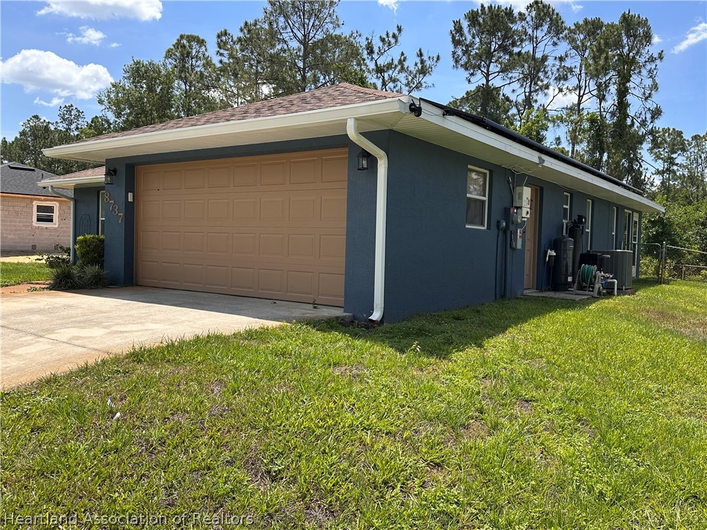 8737 Capilla Street Sebring, FL 33872 - Photo 3 of 43 a house with green field in front of it