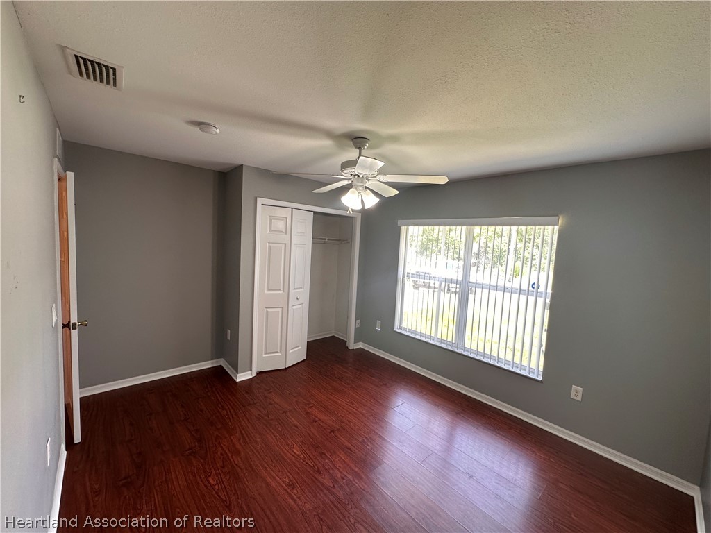 8737 Capilla Street Sebring, FL 33872 - Photo 31 of 43 an empty room with wooden floor and windows