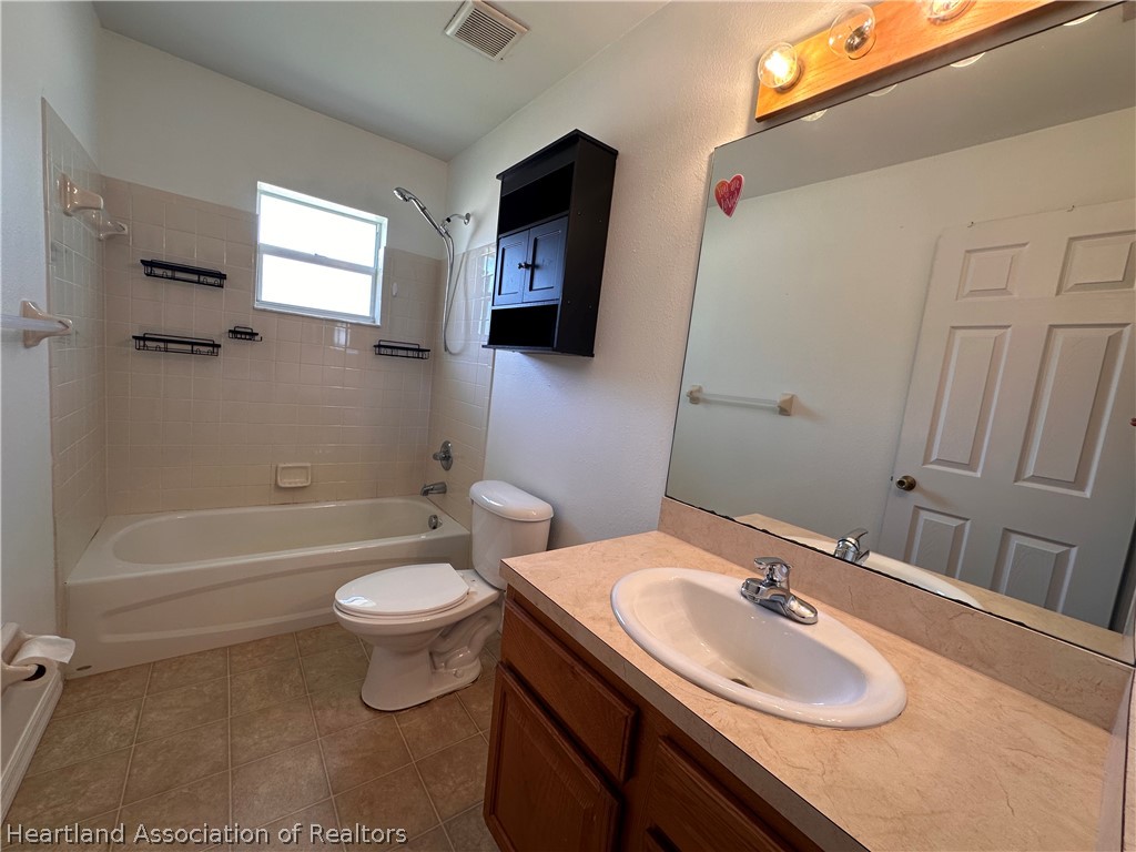 8737 Capilla Street Sebring, FL 33872 - Photo 32 of 43 a bathroom with a sink toilet mirror vanity and bathtub