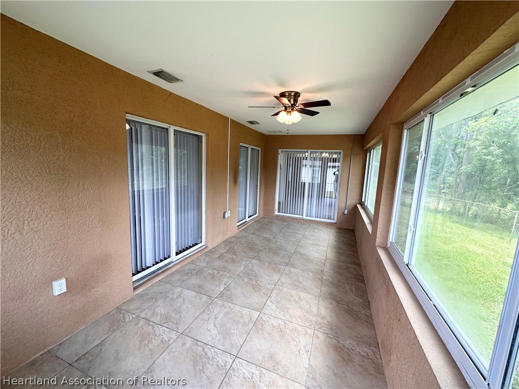 8737 Capilla Street Sebring, FL 33872 - Photo 34 of 43 a view of a porch with wooden floor and windows