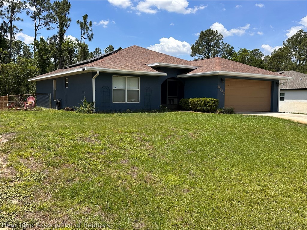 8737 Capilla Street Sebring, FL 33872 - Photo 42 of 43 a front view of a house with yard and trees
