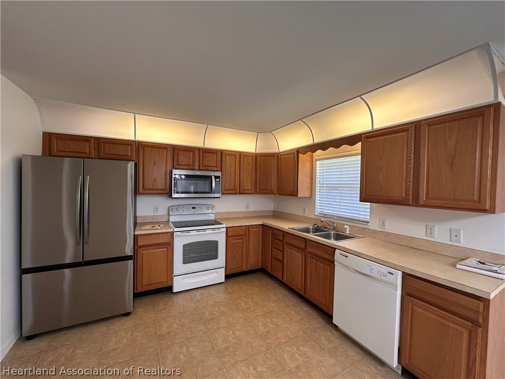 8737 Capilla Street Sebring, FL 33872 - Photo 6 of 43 a kitchen with a refrigerator sink and stove top oven