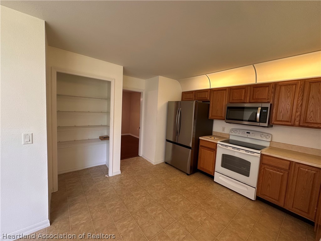8737 Capilla Street Sebring, FL 33872 - Photo 9 of 43 a kitchen with a refrigerator and a stove