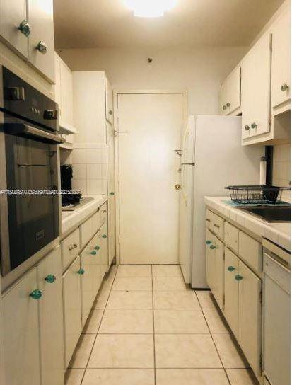 100 Lincoln Road, Unit 541 Miami Beach, FL 33139 - Photo 2 of 7 a kitchen with granite countertop a refrigerator and a stove top oven