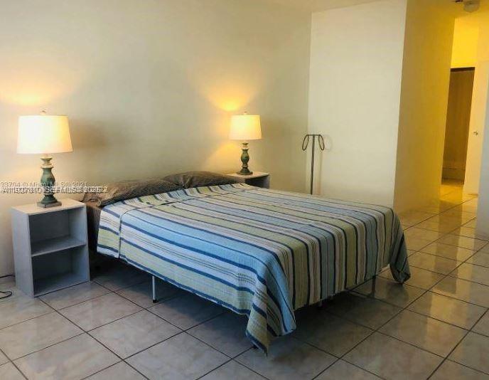 100 Lincoln Road, Unit 541 Miami Beach, FL 33139 - Photo 3 of 7 a bedroom with a bed and a lamp on table