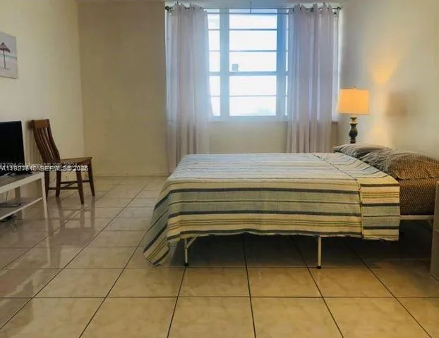 a bedroom with a bed and a chair in it