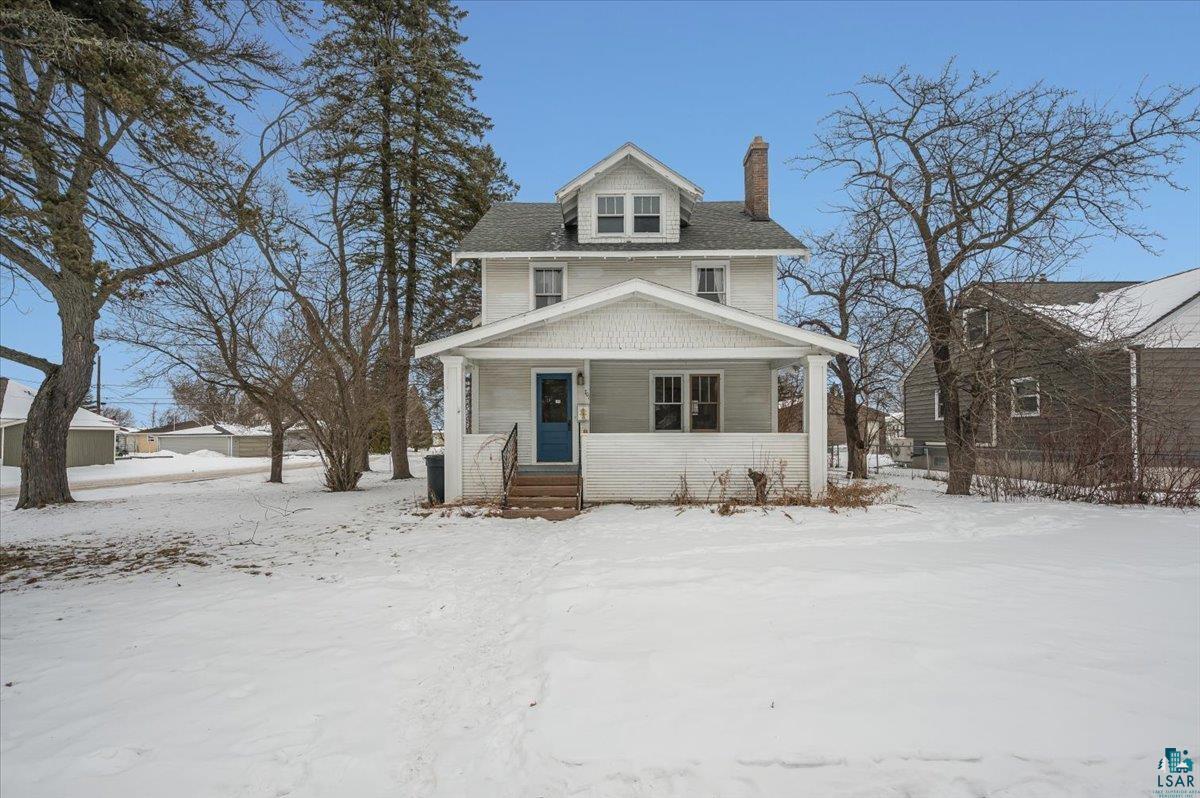 American foursquare style home with a porch and a chimney