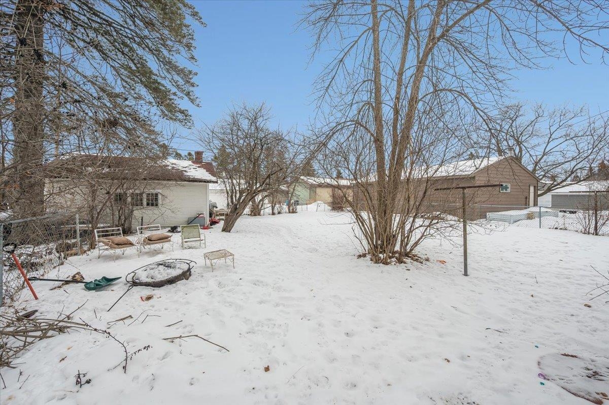 701 East 4th Street Superior, WI 54880 - Photo 14 of 16 Yard layered in snow with a fire pit and a patio