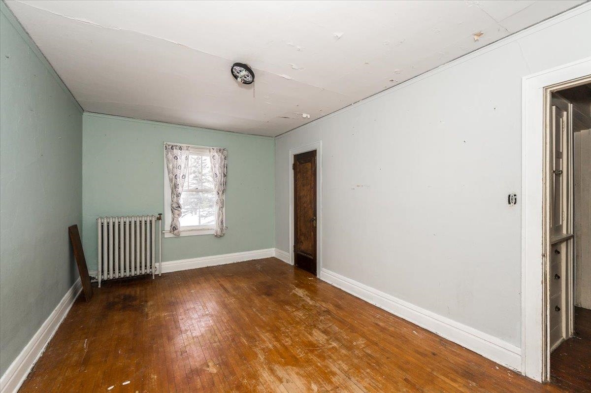 701 East 4th Street Superior, WI 54880 - Photo 7 of 16 Spare room with dark wood-type flooring and radiator heating unit