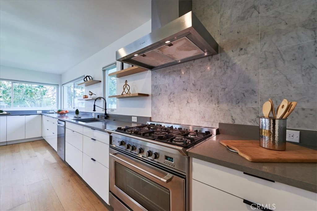 345 Broadway Costa Mesa, CA 92627 - Photo 7 of 20 a kitchen with cabinets appliances and a wooden floor