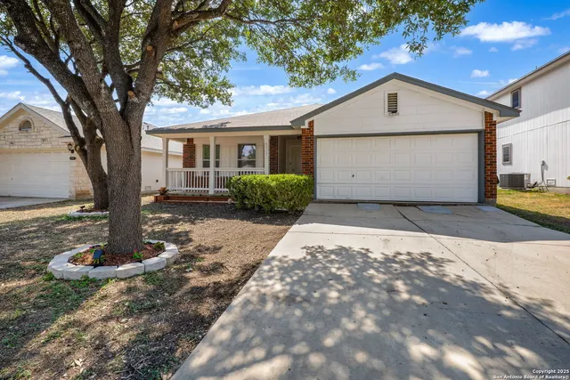 a front view of a house with a yard and tree