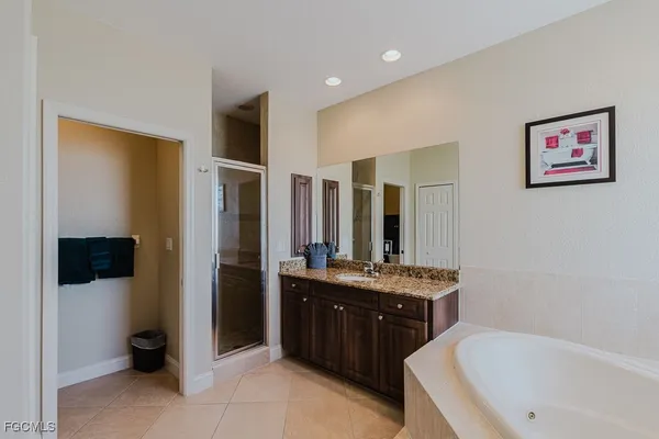 a spacious bathroom with a granite countertop sink mirror and bathtub