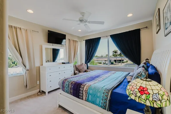 a bedroom with a bed dresser and a flat tv screen