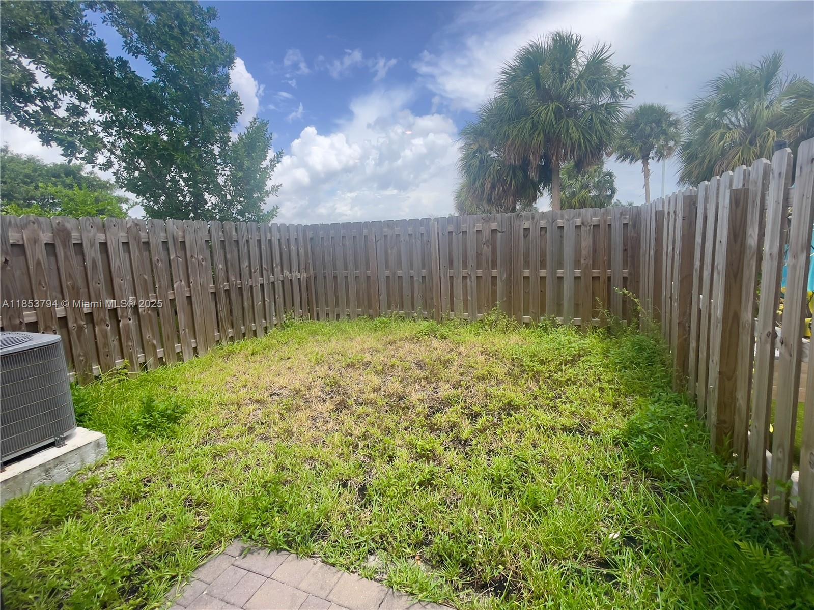 10005 Southwest 228th Terrace, Unit 10005 Miami, FL 33190 - Photo 4 of 12 a view of garden with wooden fence