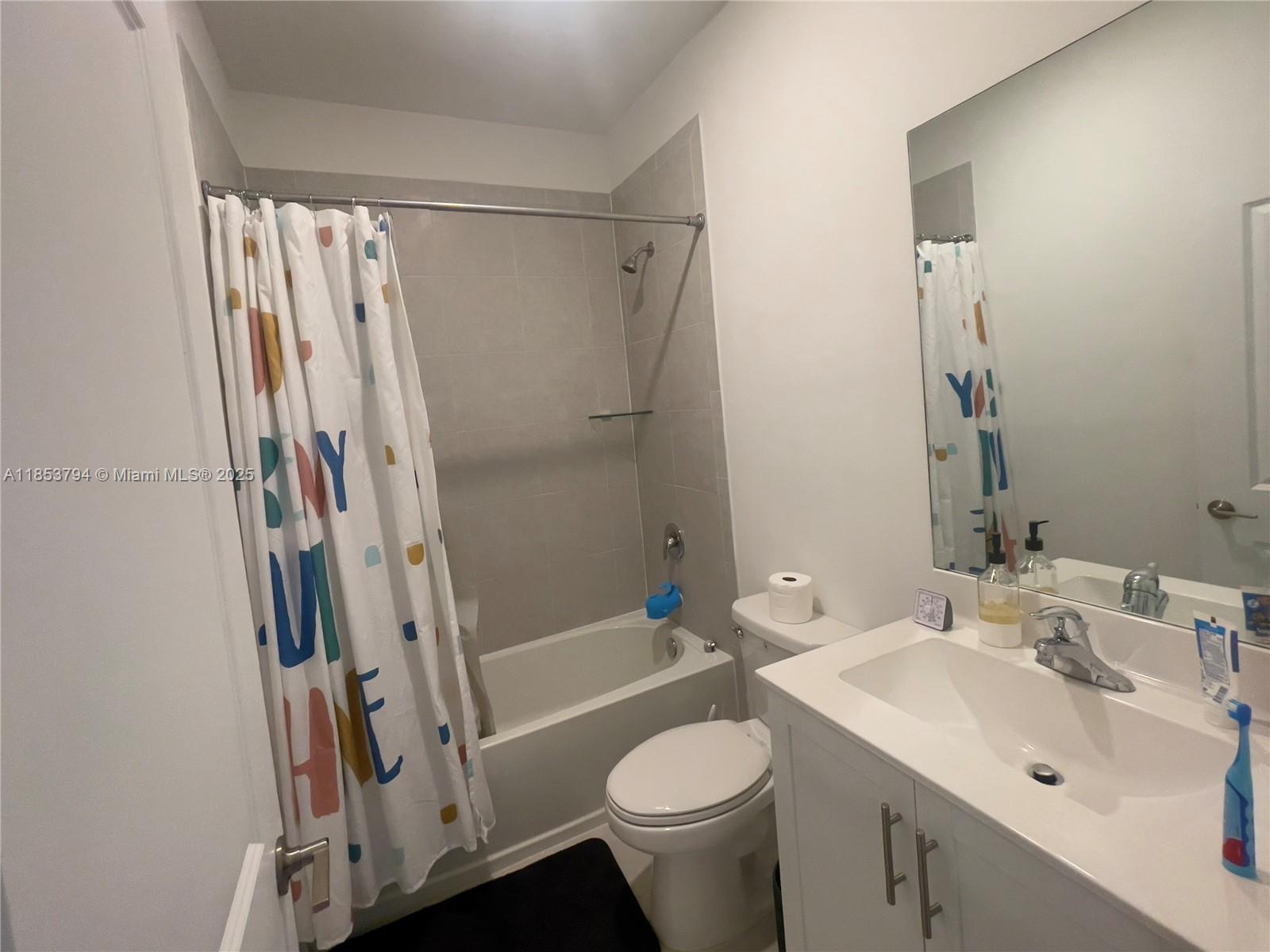 10005 Southwest 228th Terrace, Unit 10005 Miami, FL 33190 - Photo 9 of 12 a bathroom with a sink toilet and shower