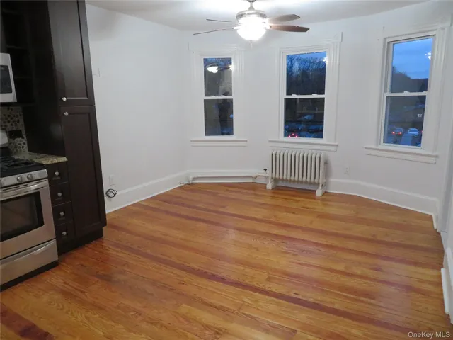 a view of empty room with stairs and wooden floor