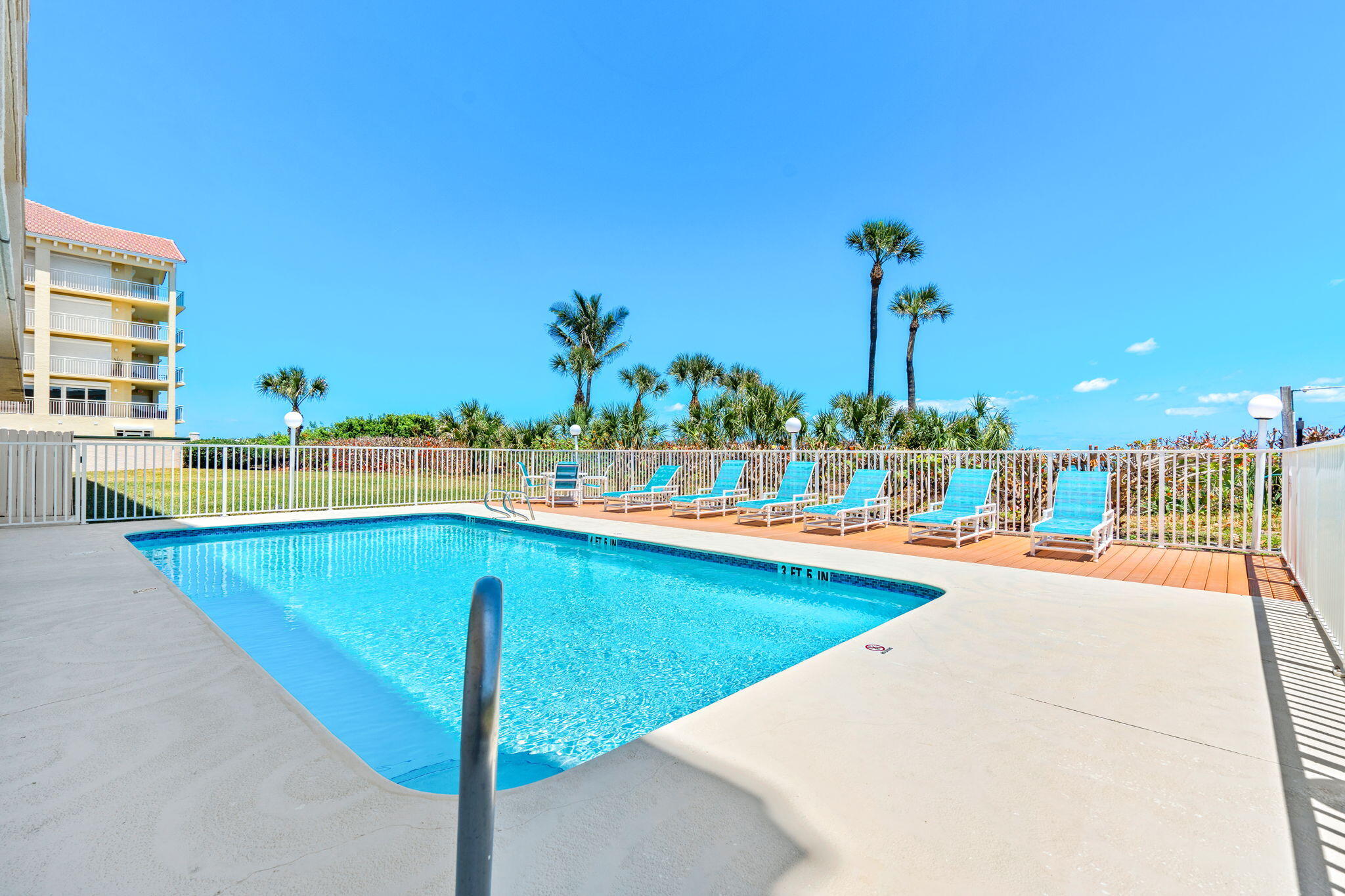1505 North Hwy A1A, Unit 304 Indialantic, FL 32903 - Photo 21 of 27 a view of a swimming pool with a lawn chairs and plants