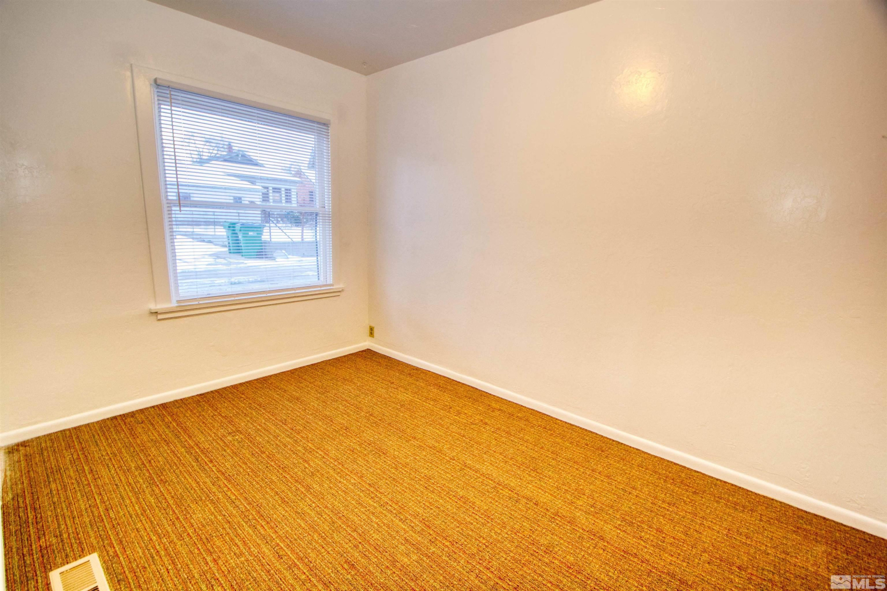 829 Plumas Street, Unit C Reno, NV 89509 - Photo 9 of 12 an empty room with a wooden floor and a window