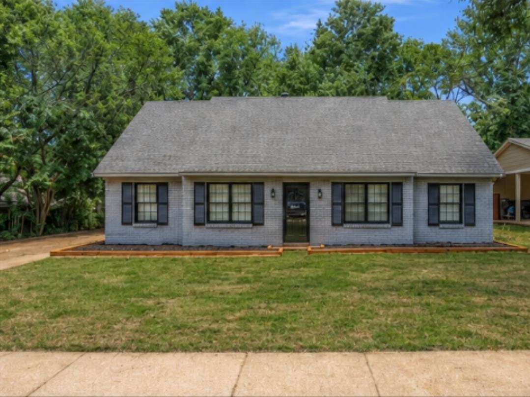 3314 Bright Ridge Cove Memphis, TN 38115 - Photo 1 of 16 Gray brick exterior featuring black window shutters and a matching black front door