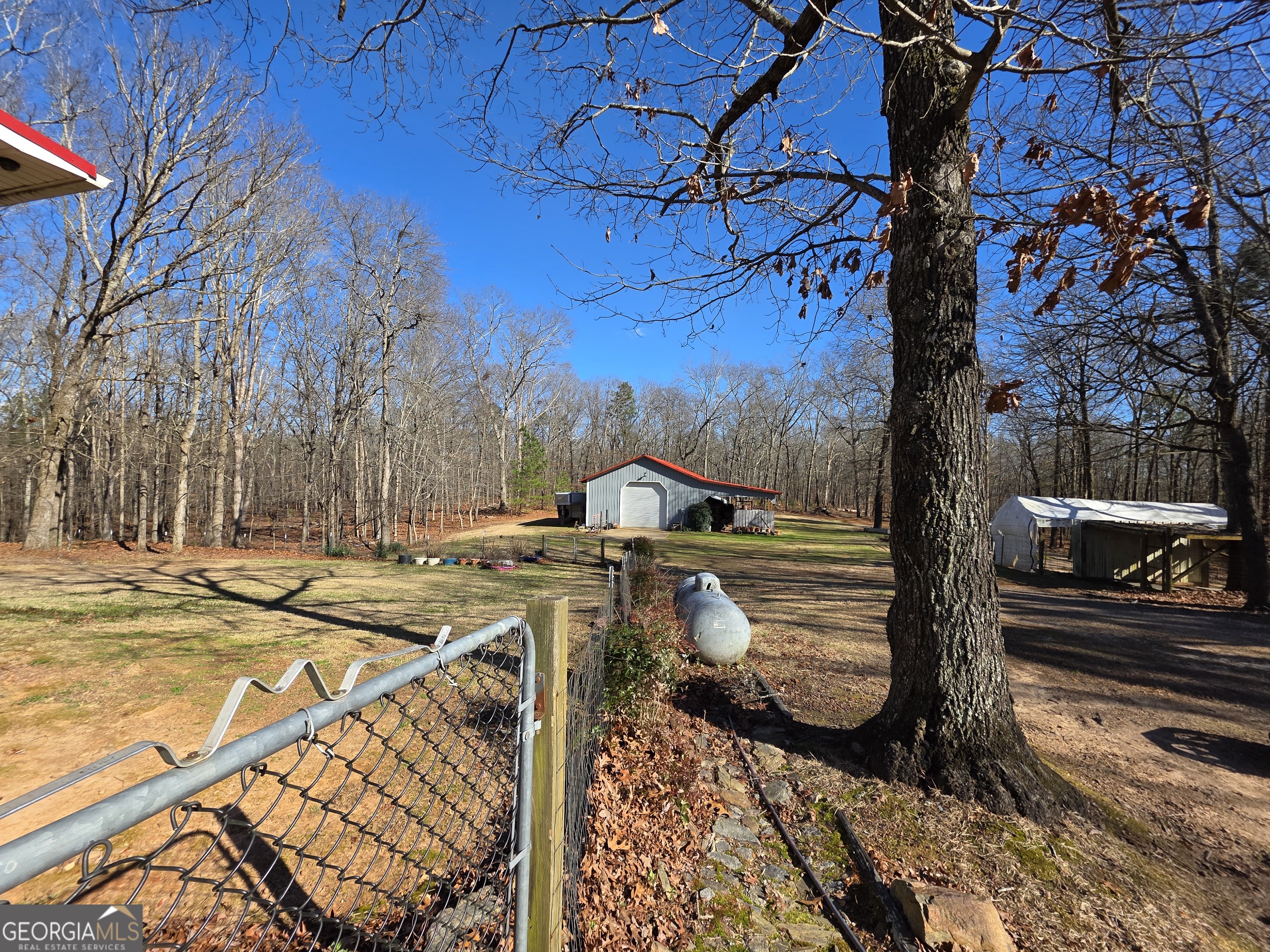 3879 Caney Head Road Roopville, GA 30217 - Photo 8 of 64 a view of a patio with table and chairs with wooden floor and fence