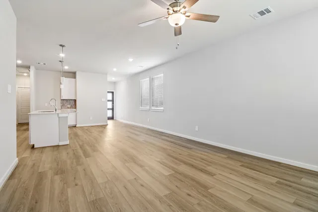 a view of empty room with wooden floor and window