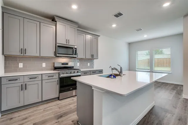 a kitchen with a sink stove and cabinets