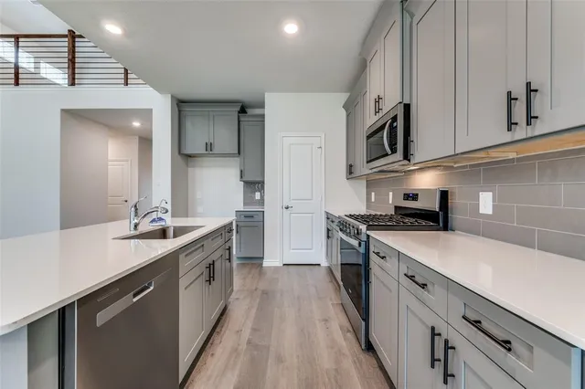 a kitchen with stainless steel appliances granite countertop a sink stove and refrigerator