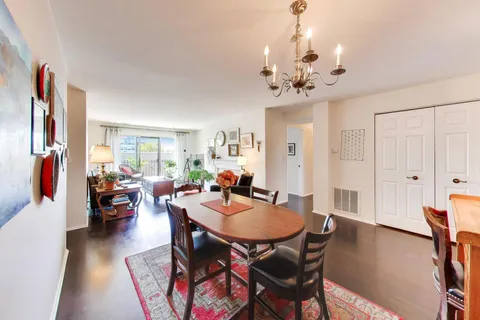 a view of a a dining room with furniture window and wooden floor