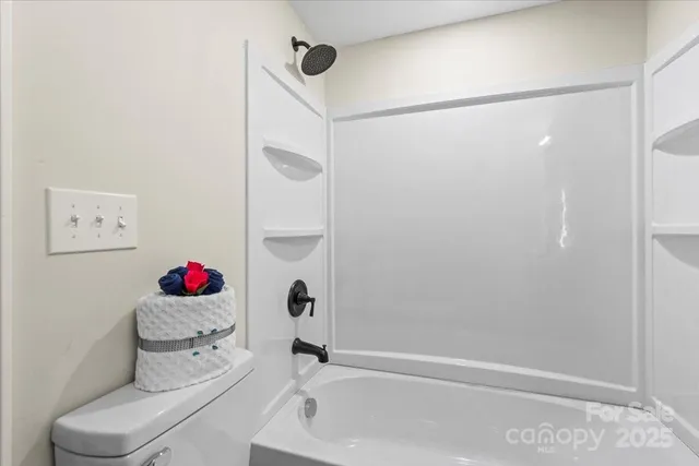 a bathroom with a toilet and a shower curtain