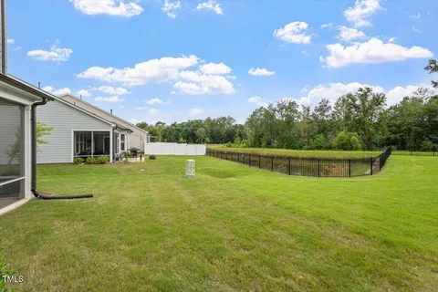 a view of a room with wooden floor a ceiling fan and windows