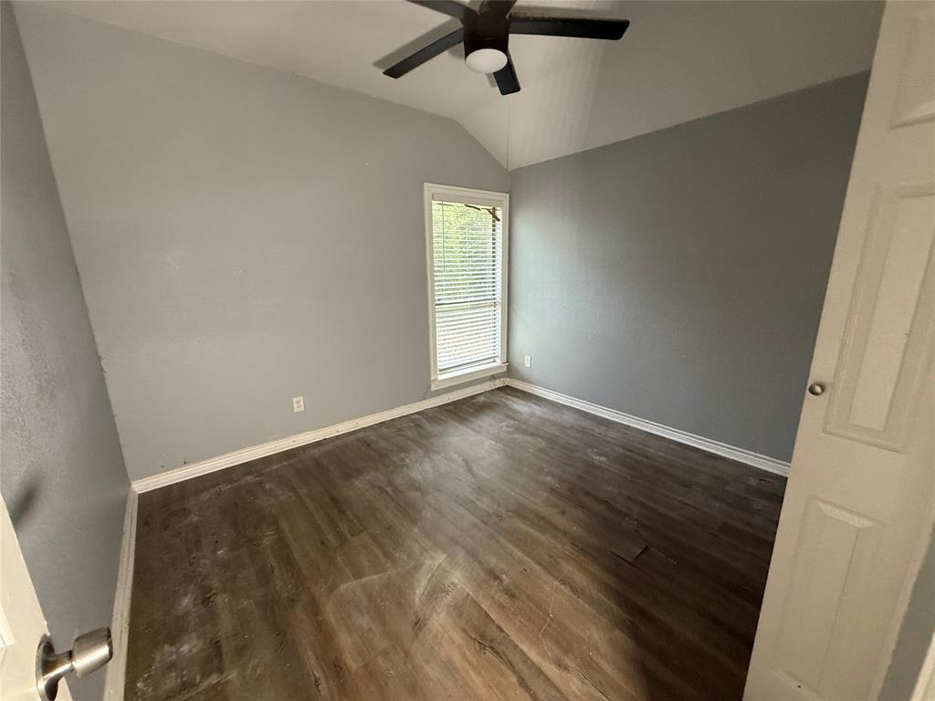 2009 Apache Road Quinlan, TX 75474 - Photo 15 of 19 an empty room with wooden floor ceiling fan and windows