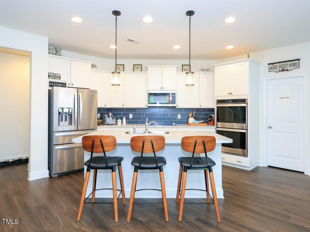 110 Point View Way Franklinton, NC 27525 - Photo 19 of 62 a kitchen with stainless steel appliances granite countertop a dining table chairs refrigerator and sink