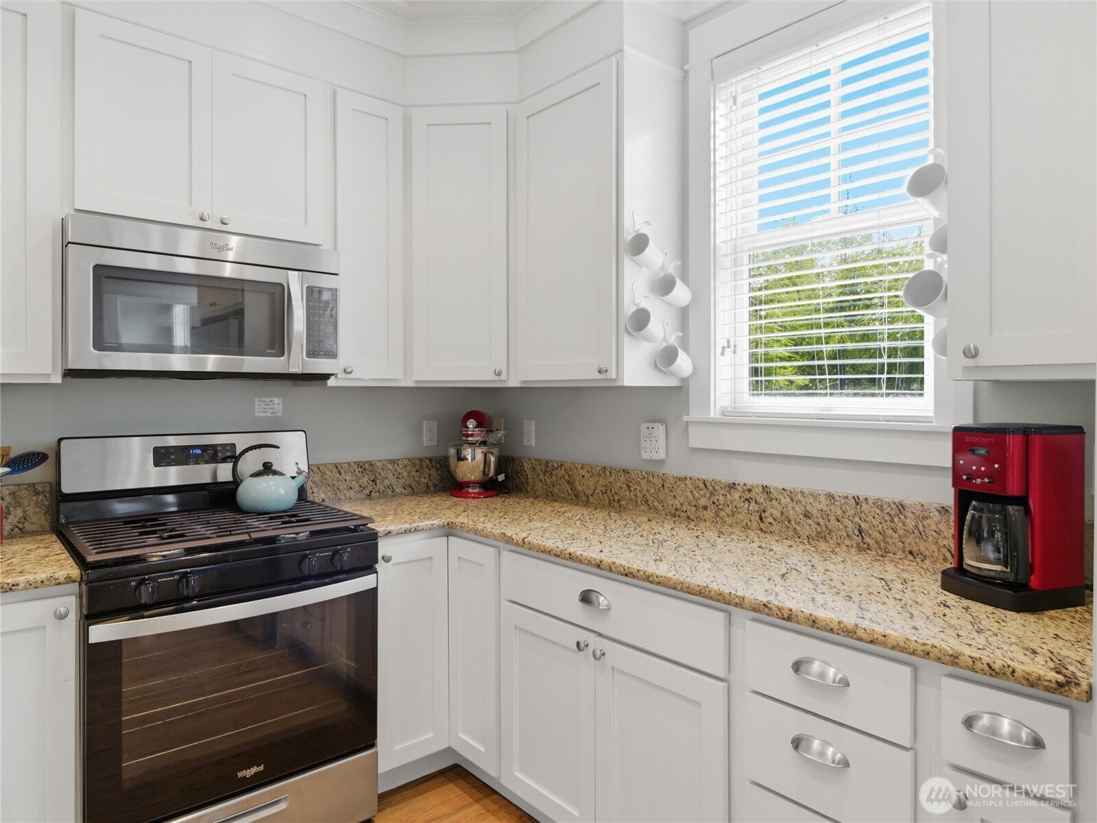 269 Compass Street Pacific Beach, WA 98571 - Photo 11 of 38 a kitchen with granite countertop white cabinets appliances and a window