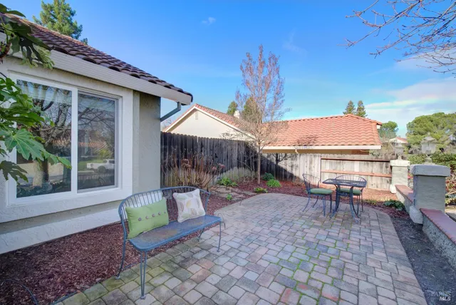 a large kitchen with kitchen island a stove a refrigerator a sink a dining table and chairs with wooden floor