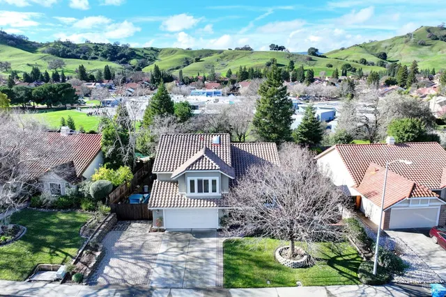 a front view of a house with a garden and trees