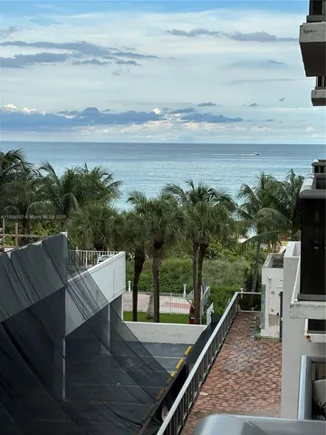 a view of a balcony with furniture and a floor to ceiling window
