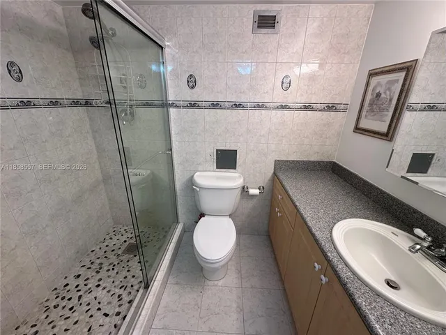 a bathroom with a granite countertop toilet sink and shower