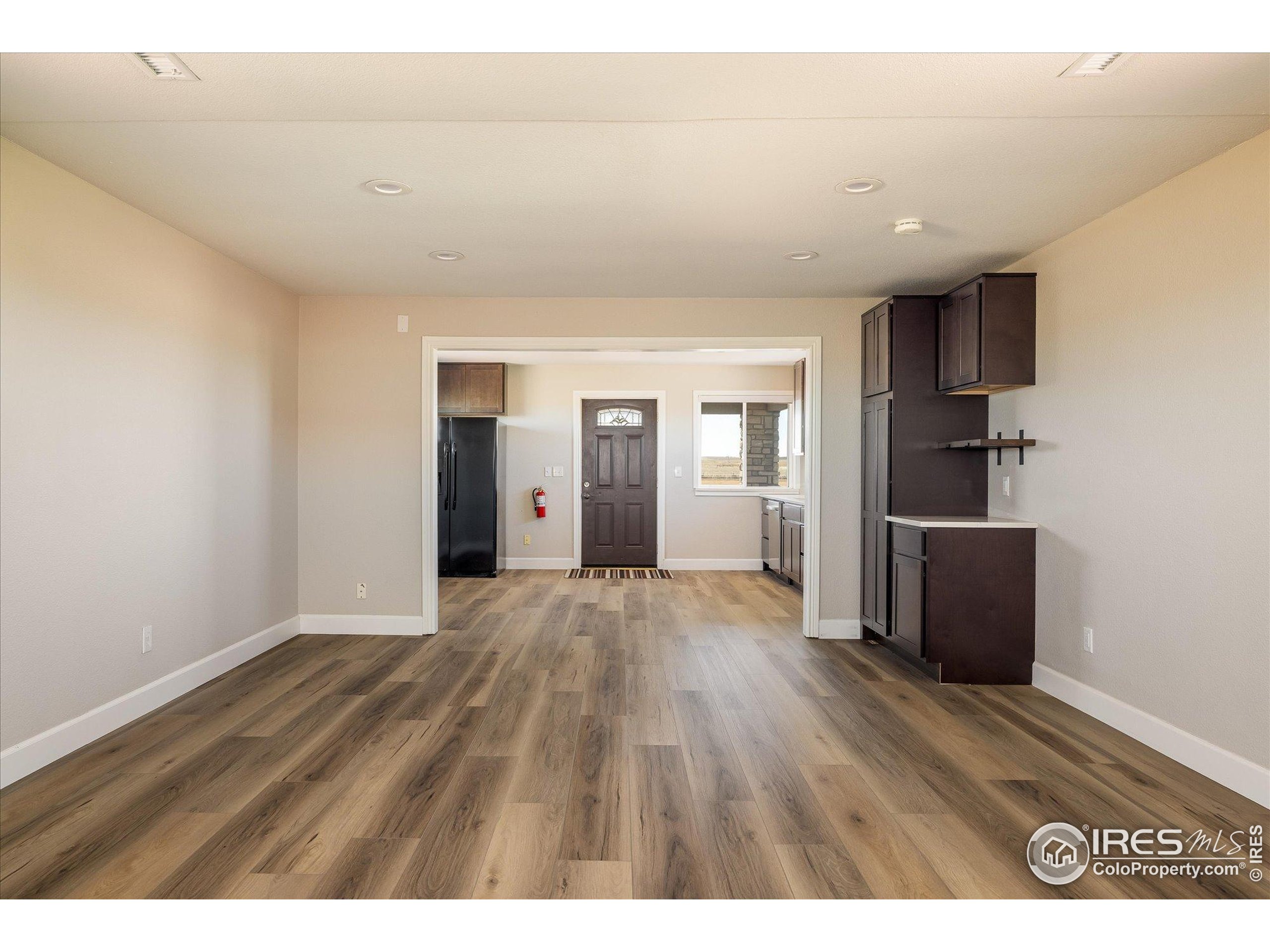 13400 Harvest Road Commerce City, CO 80022 - Photo 31 of 50 a view of an empty room with wooden floor and kitchen