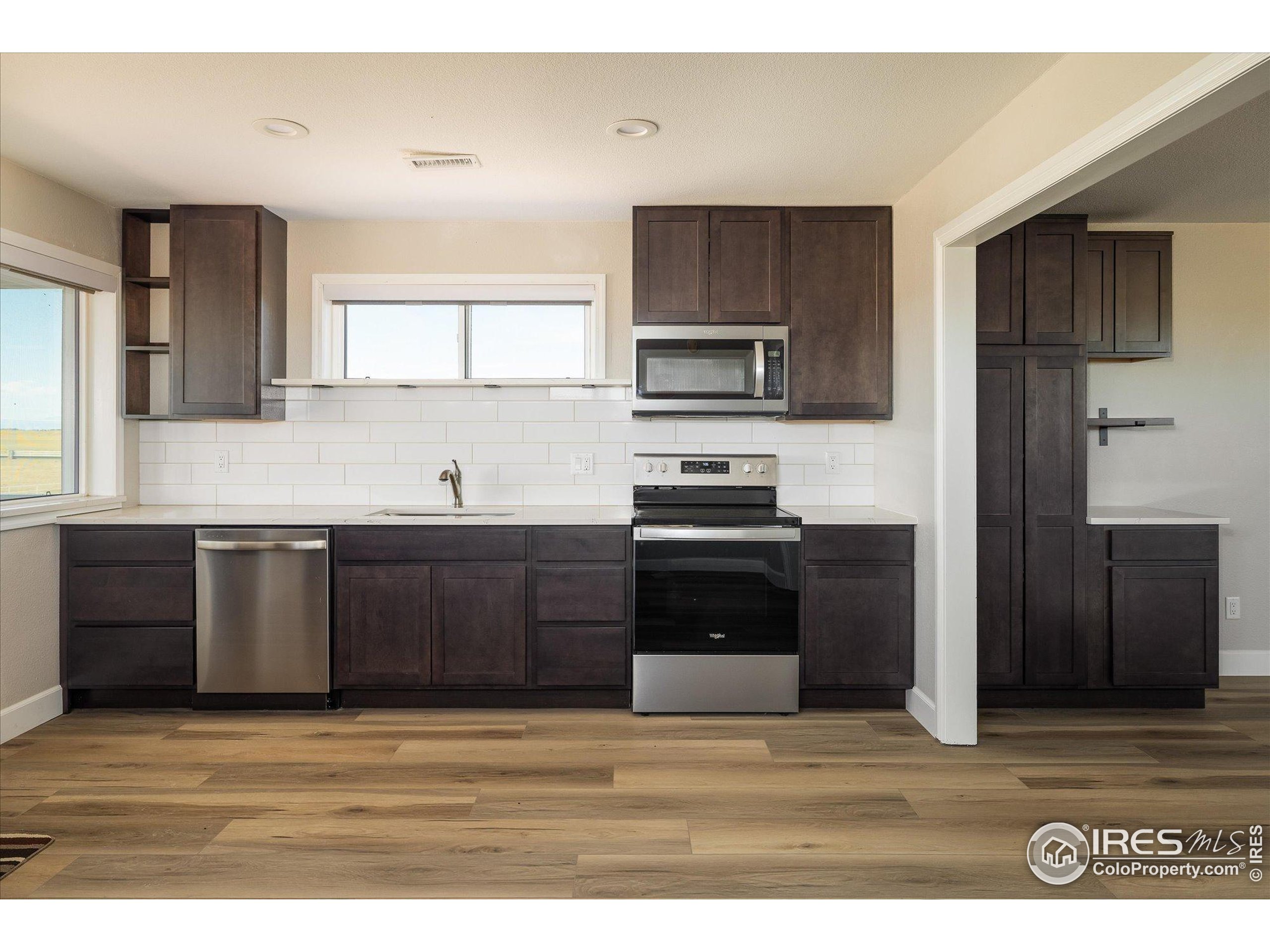 13400 Harvest Road Commerce City, CO 80022 - Photo 34 of 50 a kitchen with stainless steel appliances kitchen island granite countertop a refrigerator stove and sink