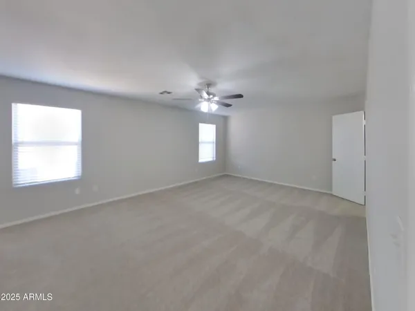 a view of an empty room with a chandelier fan
