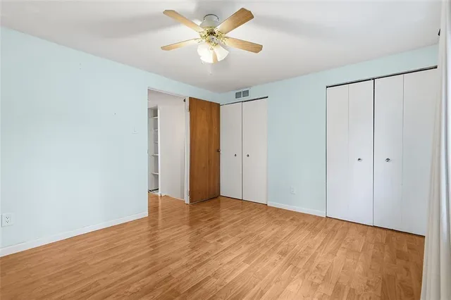 a view of an empty room with closet and a chandelier fan