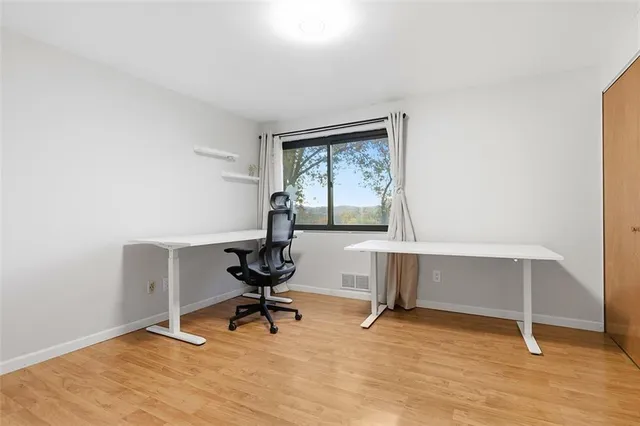 a view of a workspace with furniture and a window