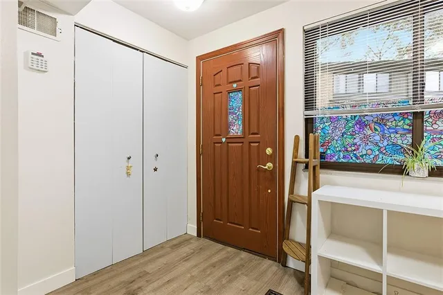 a view of a hallway with wooden floor and cabinet