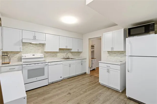 a kitchen with white cabinets and white appliances