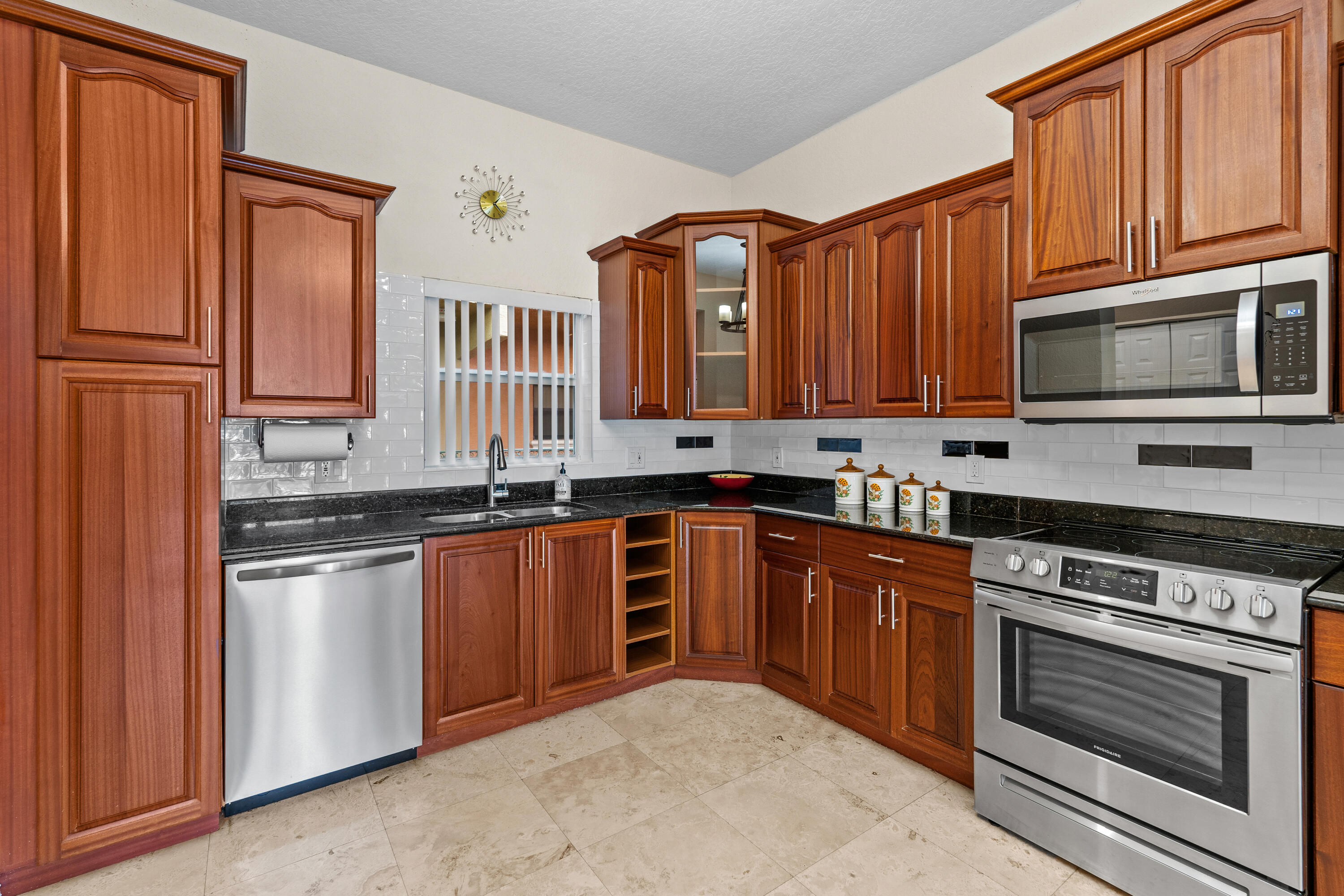 a kitchen with stainless steel appliances granite countertop a stove top oven microwave and cabinets