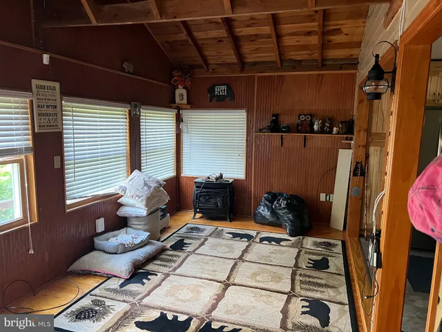 a view of a livingroom with furniture wooden floor a ceiling fan and windows