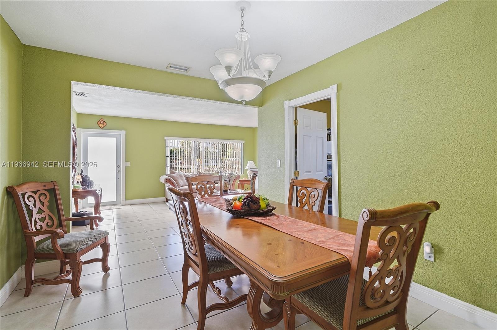 4791 West 3rd Avenue Hialeah, FL 33012 - Photo 14 of 30 a dining room with furniture a rug and a chandelier
