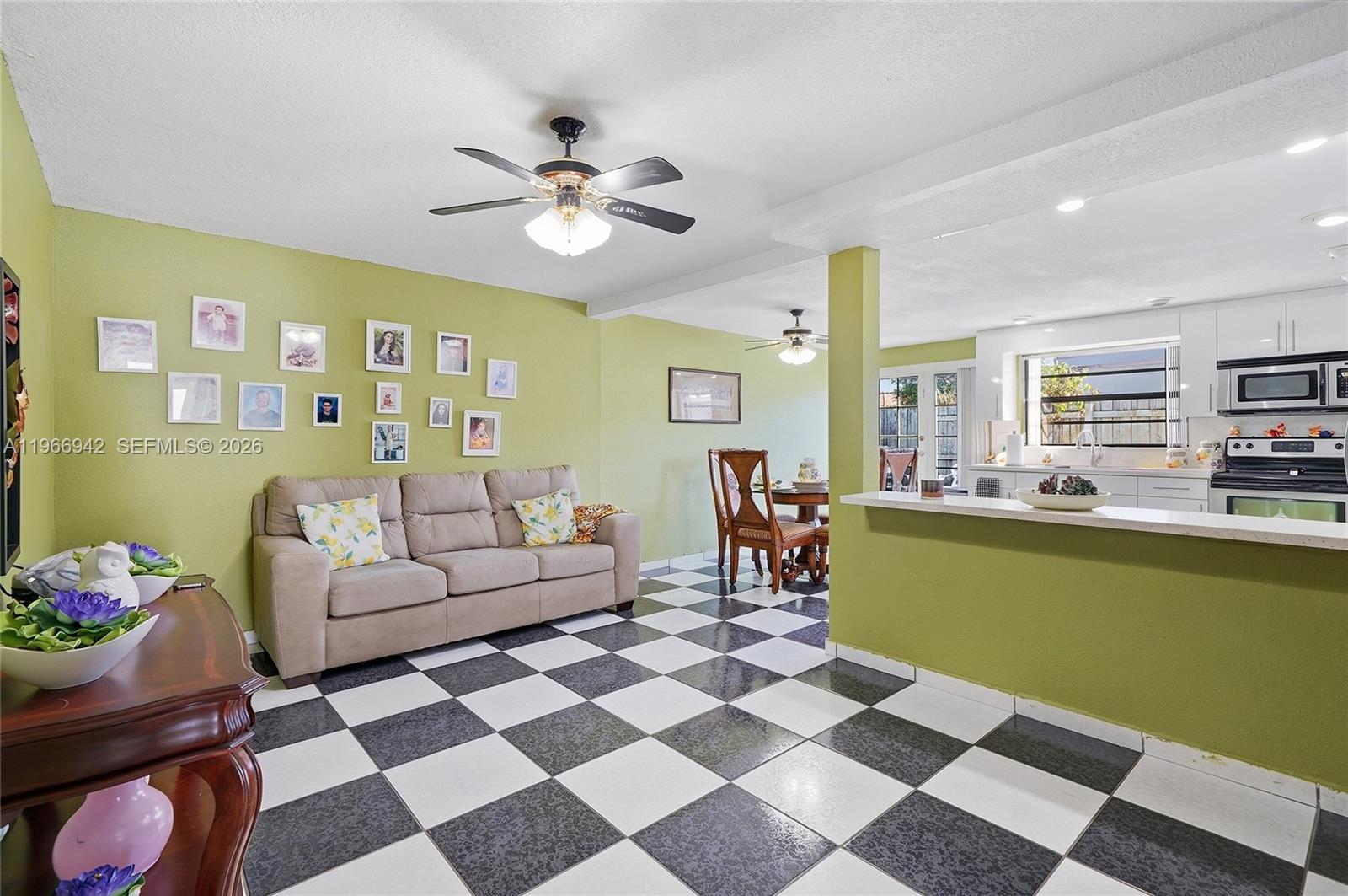 4791 West 3rd Avenue Hialeah, FL 33012 - Photo 16 of 30 a living room with furniture and a dining table with kitchen view