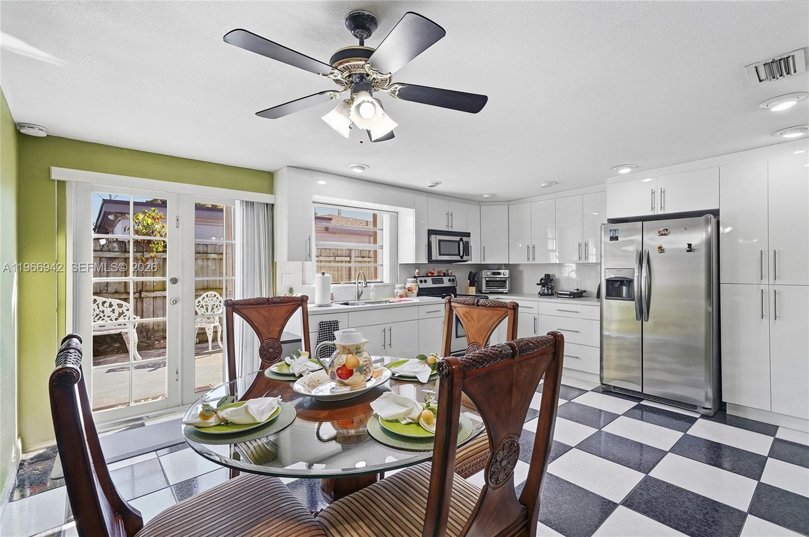 4791 West 3rd Avenue Hialeah, FL 33012 - Photo 18 of 30 a dining room with furniture a kitchen view and a chandelier